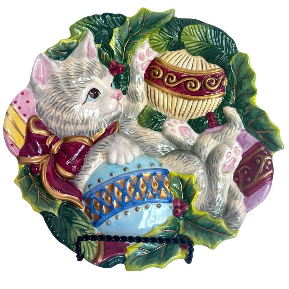 Cute Gray Kitten Plays with Christmas Tree Ornaments on a Decorative Plate.